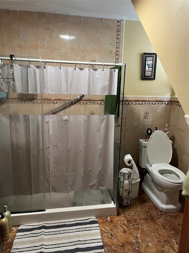 bathroom with toilet, tile walls, and a shower with curtain