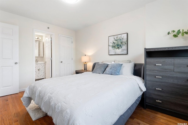 bedroom with hardwood / wood-style flooring and connected bathroom