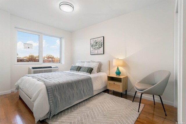 bedroom featuring a wall unit AC and hardwood / wood-style floors