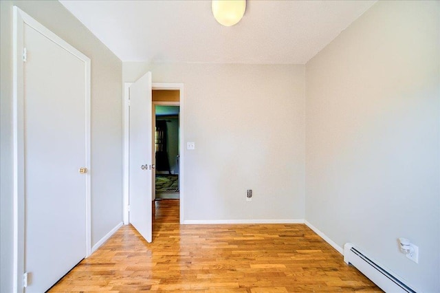 400 Philo St, New Windsor, NY 12553 - empty room with a baseboard heating unit, light wood-style flooring, and baseboards