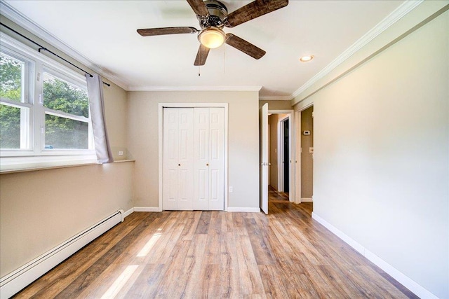 400 Philo St, New Windsor, NY 12553 - unfurnished bedroom featuring a baseboard heating unit, wood finished floors, baseboards, ornamental molding, and a closet
