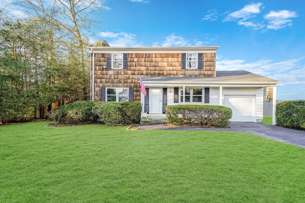 front of property featuring a front lawn and a garage