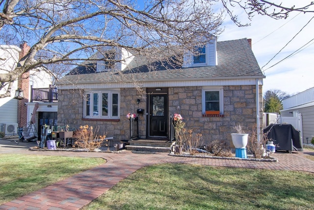 view of front of house featuring ac unit and a front lawn