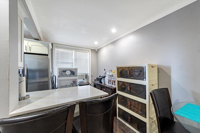 kitchen with white cabinets, stainless steel fridge, crown molding, and kitchen peninsula