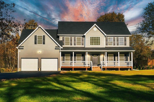 view of front facade with a garage, a porch, and a lawn