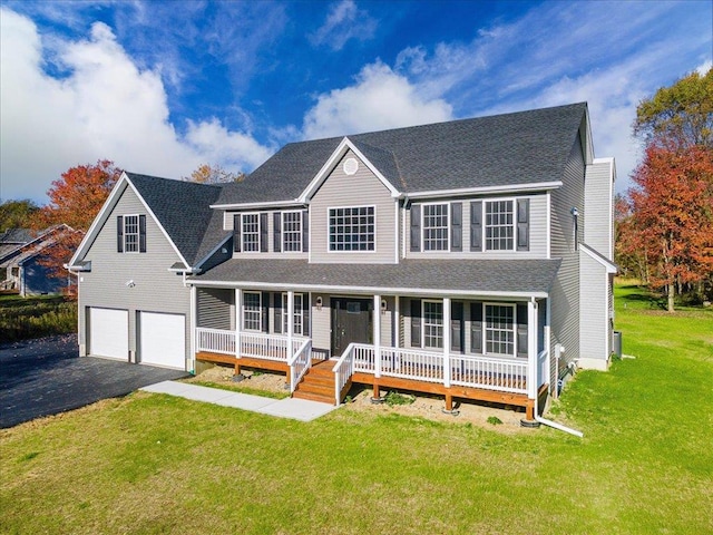 view of front of property with a front yard, a garage, and covered porch