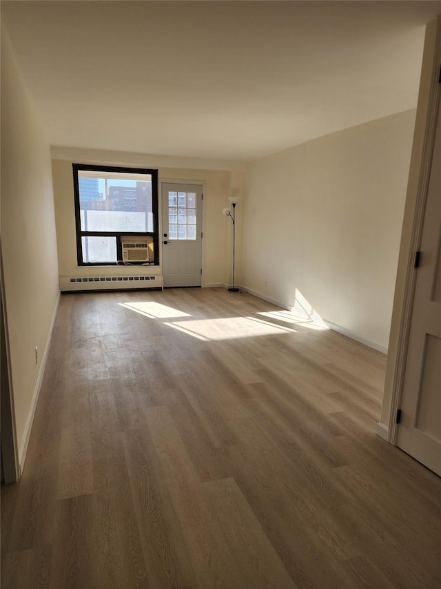 interior space featuring baseboard heating and hardwood / wood-style flooring