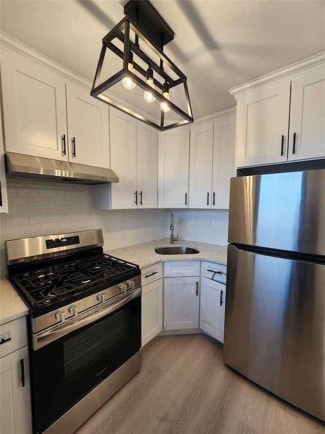 kitchen with white cabinets, appliances with stainless steel finishes, light hardwood / wood-style floors, and sink