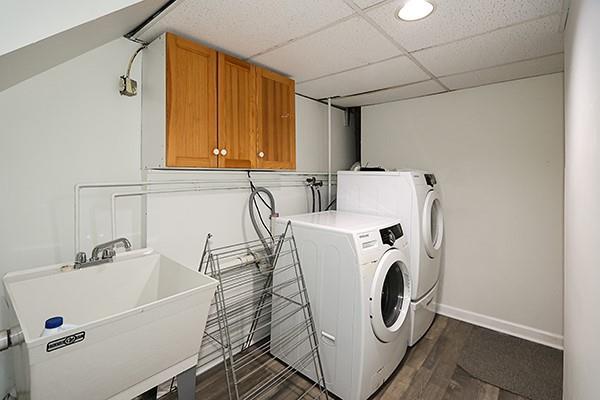 washroom featuring sink, cabinets, dark hardwood / wood-style floors, and washer and dryer