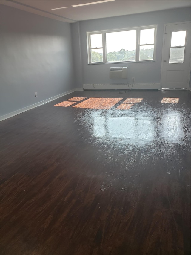 unfurnished room with an AC wall unit and dark hardwood / wood-style floors