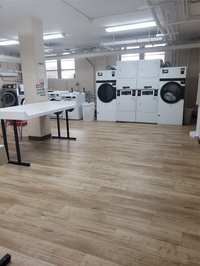 washroom with light wood-type flooring and stacked washer / dryer