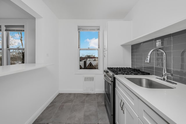 kitchen with sink, white cabinetry, and tasteful backsplash