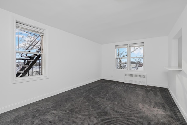 carpeted empty room with radiator heating unit