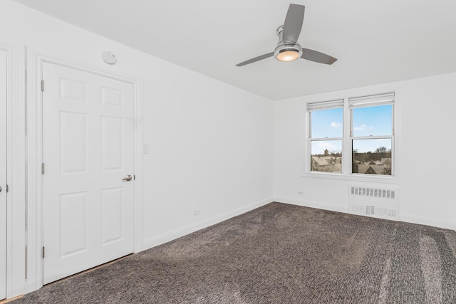 carpeted empty room featuring ceiling fan and radiator heating unit