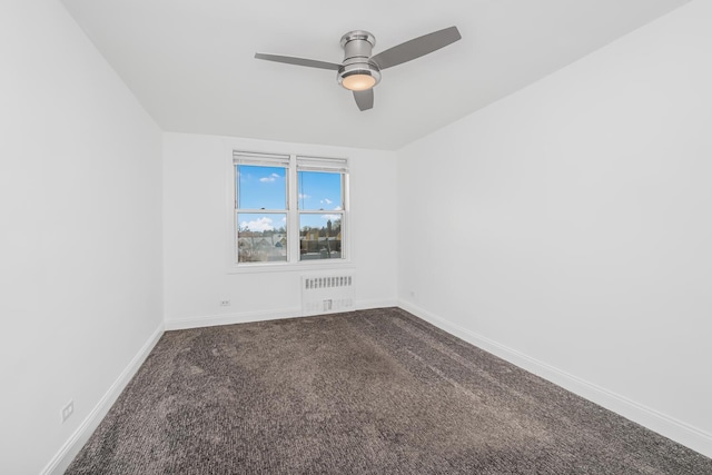 carpeted spare room with radiator and ceiling fan