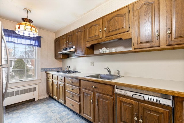 kitchen featuring sink, hanging light fixtures, radiator heating unit, and stainless steel appliances