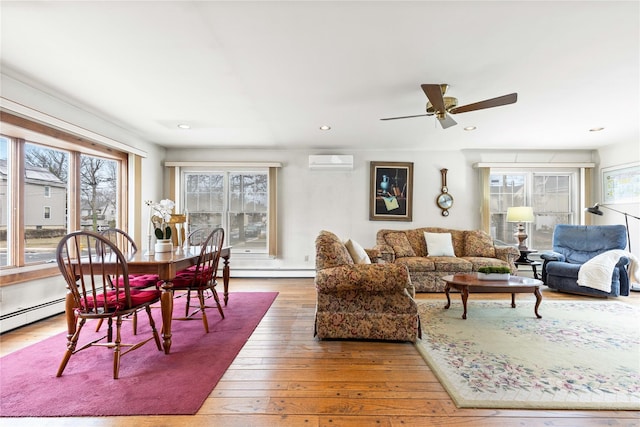 living room featuring ceiling fan, a wall mounted air conditioner, a baseboard radiator, and hardwood / wood-style flooring