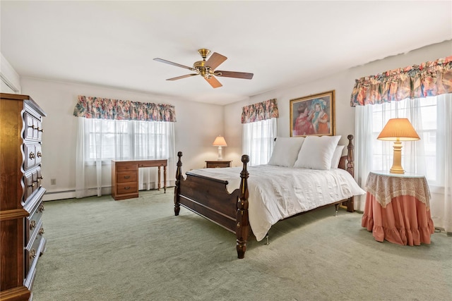 carpeted bedroom featuring a baseboard heating unit, ceiling fan, and multiple windows