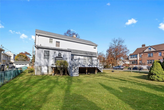 back of property with a deck and a lawn