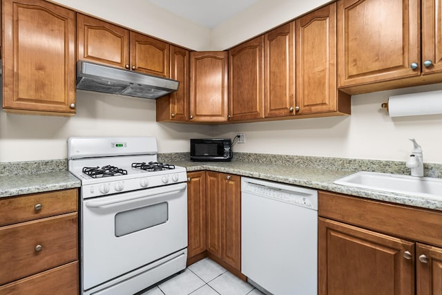 kitchen with white appliances, light tile patterned floors, and sink