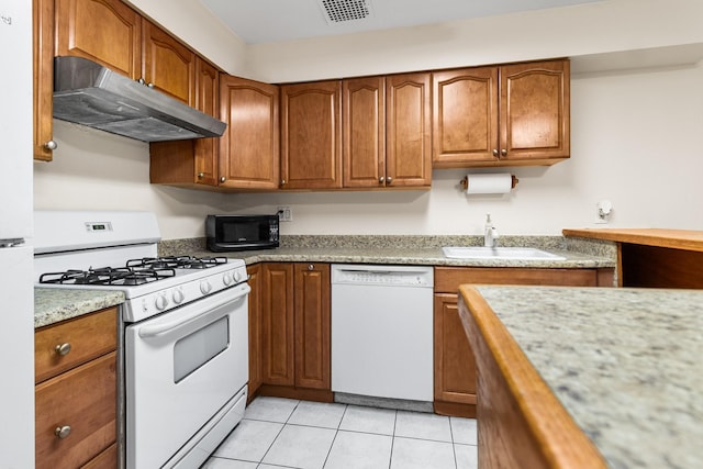 kitchen featuring white appliances, sink, and light tile patterned floors