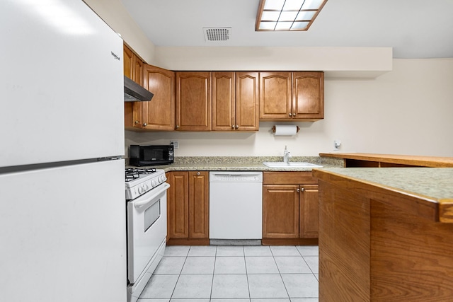 kitchen with sink, white appliances, range hood, and light tile patterned floors