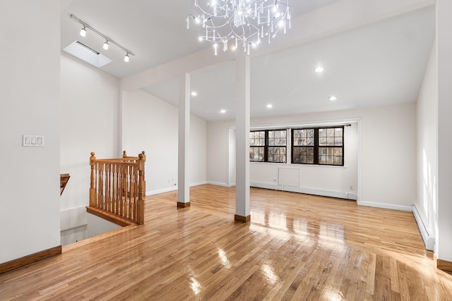 interior space with a notable chandelier, baseboard heating, and hardwood / wood-style flooring