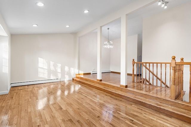 interior space with a baseboard radiator, hardwood / wood-style flooring, and a notable chandelier