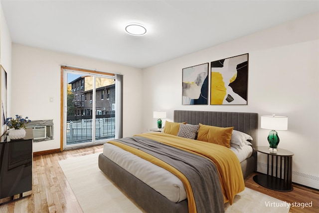 bedroom featuring light hardwood / wood-style floors, radiator, and access to exterior