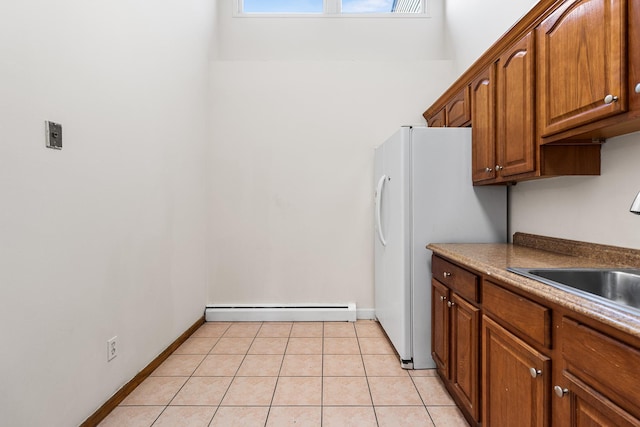 kitchen featuring sink, light tile patterned flooring, and baseboard heating