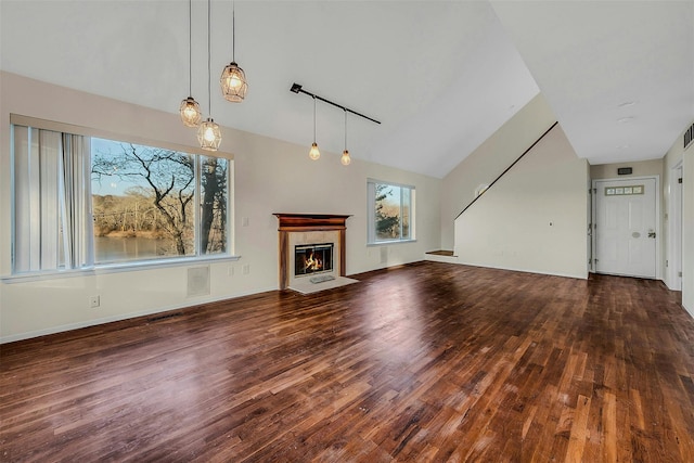 unfurnished living room with track lighting, vaulted ceiling, and hardwood / wood-style floors