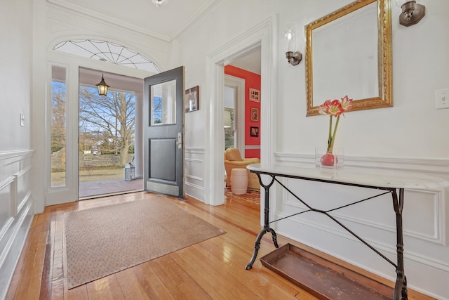 foyer with wood-type flooring and ornamental molding