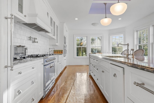 kitchen featuring white cabinetry, sink, and decorative light fixtures