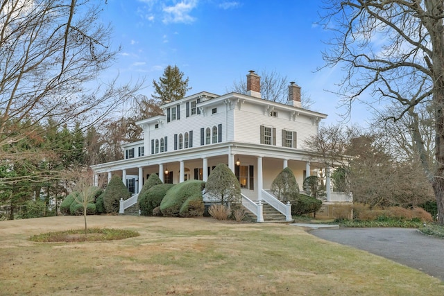 italianate-style house with covered porch and a front yard