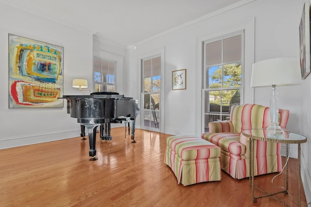 living area with hardwood / wood-style flooring and ornamental molding