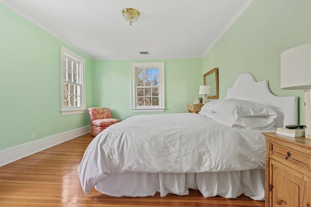 bedroom featuring ornamental molding and light hardwood / wood-style floors