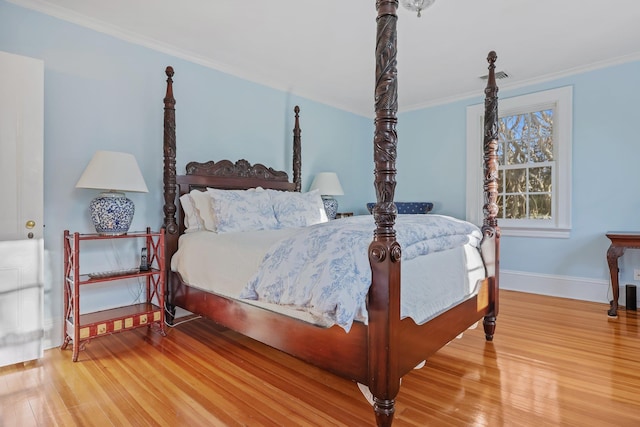 bedroom with ornamental molding and wood-type flooring