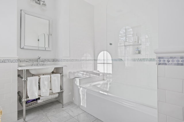 bathroom featuring tile walls and washtub / shower combination