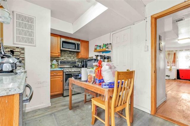 kitchen with backsplash and appliances with stainless steel finishes