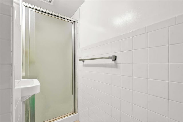 bathroom with walk in shower and tile walls