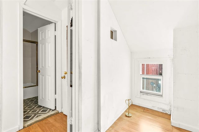 hall with hardwood / wood-style flooring and lofted ceiling