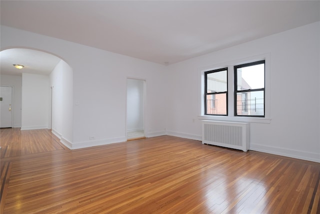 spare room featuring hardwood / wood-style flooring and radiator heating unit