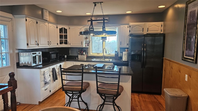 kitchen with a kitchen island, stainless steel appliances, white cabinets, and sink