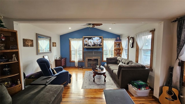 living room with ceiling fan, light hardwood / wood-style flooring, and lofted ceiling with beams