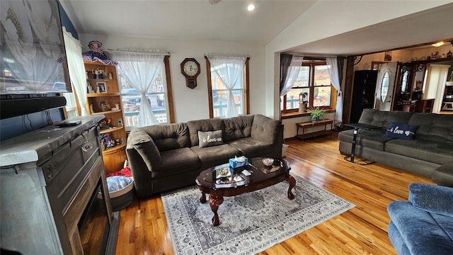 living room with vaulted ceiling, light hardwood / wood-style floors, and plenty of natural light