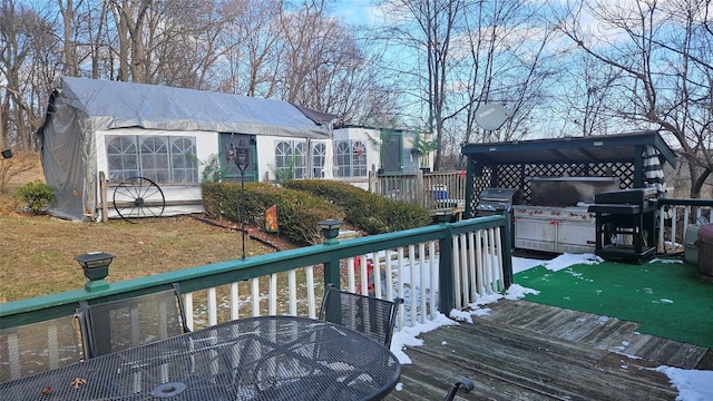 wooden terrace with area for grilling and a lawn