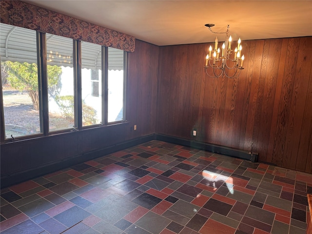 unfurnished dining area with wood walls and a notable chandelier