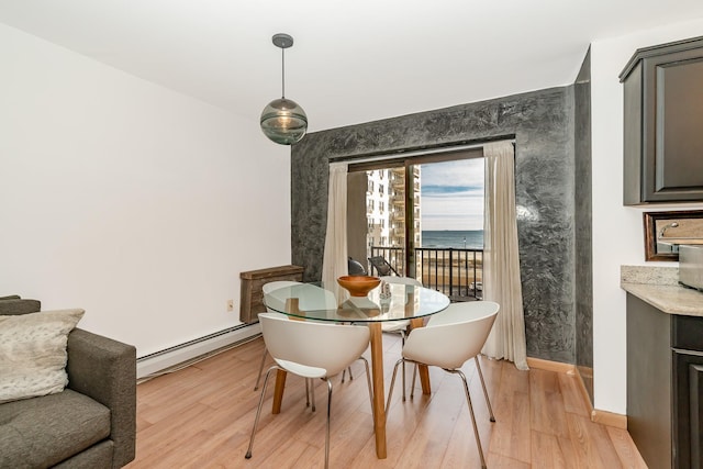 dining space featuring a baseboard radiator and light hardwood / wood-style flooring