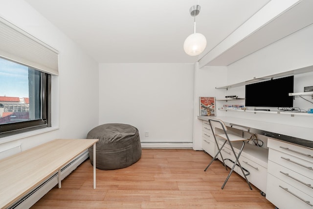 office area featuring built in desk, light hardwood / wood-style flooring, and a baseboard heating unit