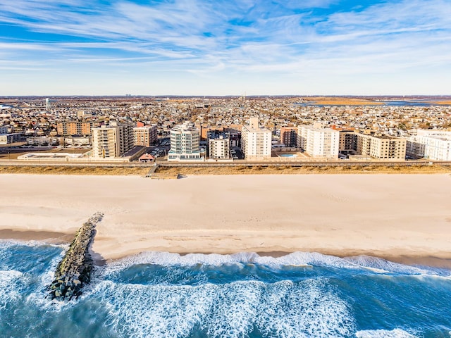 birds eye view of property with a water view and a beach view